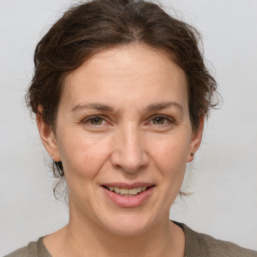 Joyful white adult female with medium  brown hair and brown eyes