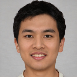 Joyful asian young-adult male with short  black hair and brown eyes