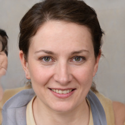 Joyful white young-adult female with medium  brown hair and blue eyes