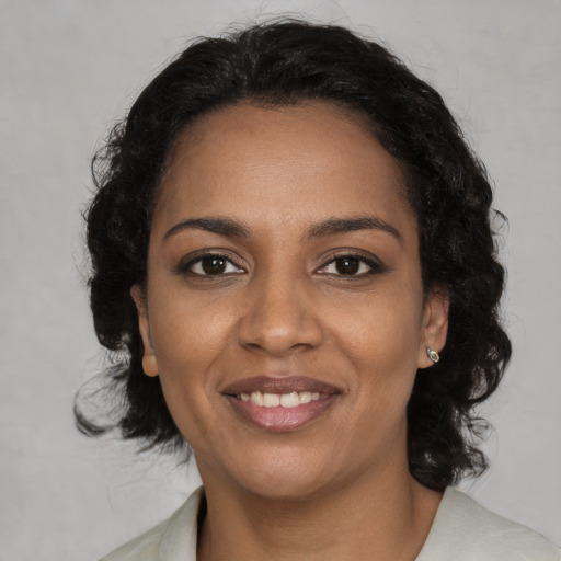 Joyful black young-adult female with medium  brown hair and brown eyes