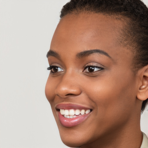 Joyful black young-adult female with short  brown hair and brown eyes