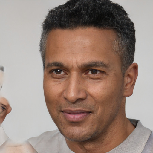 Joyful latino adult male with short  brown hair and brown eyes