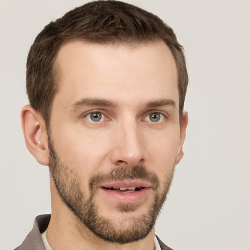 Joyful white young-adult male with short  brown hair and grey eyes