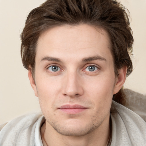 Joyful white young-adult male with short  brown hair and grey eyes