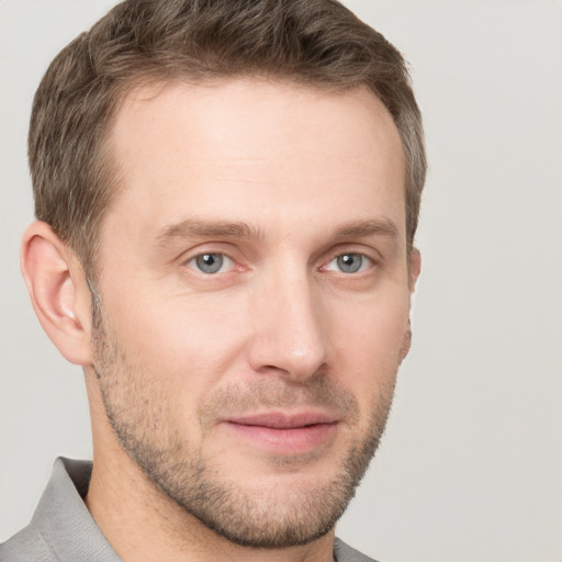 Joyful white young-adult male with short  brown hair and grey eyes