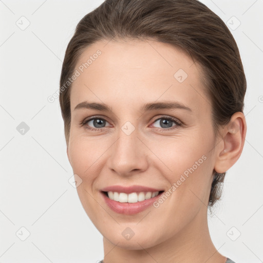 Joyful white young-adult female with medium  brown hair and grey eyes