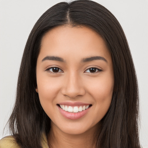 Joyful latino young-adult female with long  brown hair and brown eyes