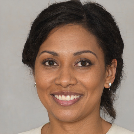 Joyful black adult female with medium  brown hair and brown eyes