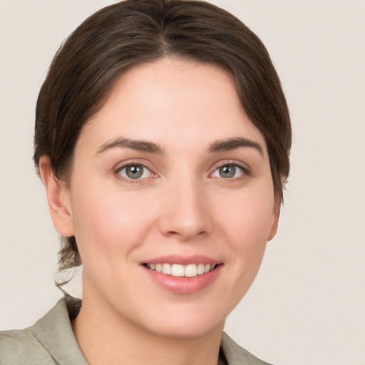 Joyful white young-adult female with medium  brown hair and grey eyes