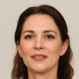 Joyful white adult female with long  brown hair and grey eyes