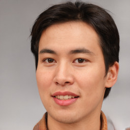 Joyful asian young-adult male with short  brown hair and brown eyes