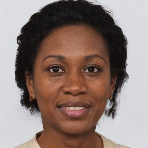 Joyful black adult female with medium  brown hair and brown eyes