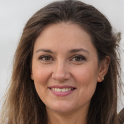 Joyful white adult female with long  brown hair and brown eyes