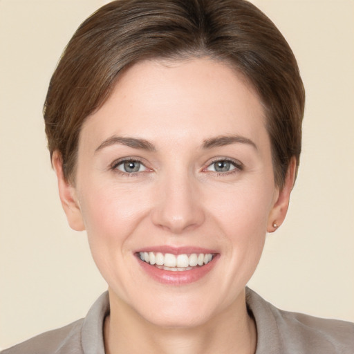 Joyful white young-adult female with short  brown hair and grey eyes