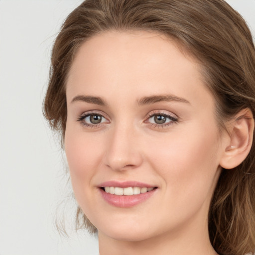 Joyful white young-adult female with long  brown hair and blue eyes