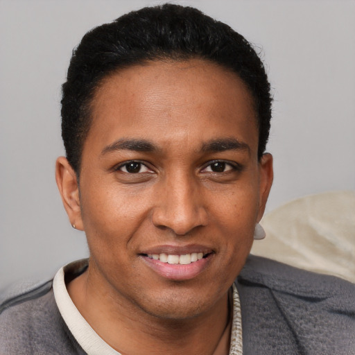 Joyful black young-adult male with short  brown hair and brown eyes