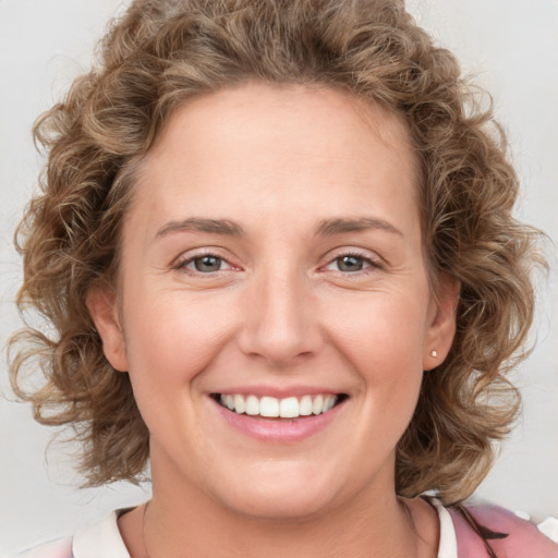 Joyful white young-adult female with medium  brown hair and green eyes