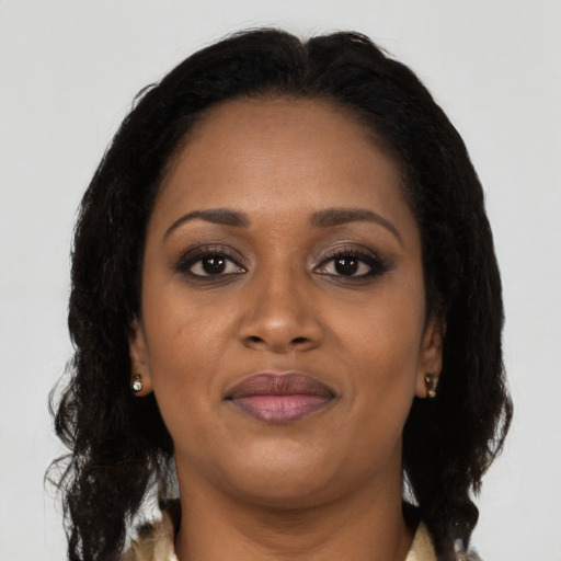 Joyful black adult female with long  brown hair and brown eyes