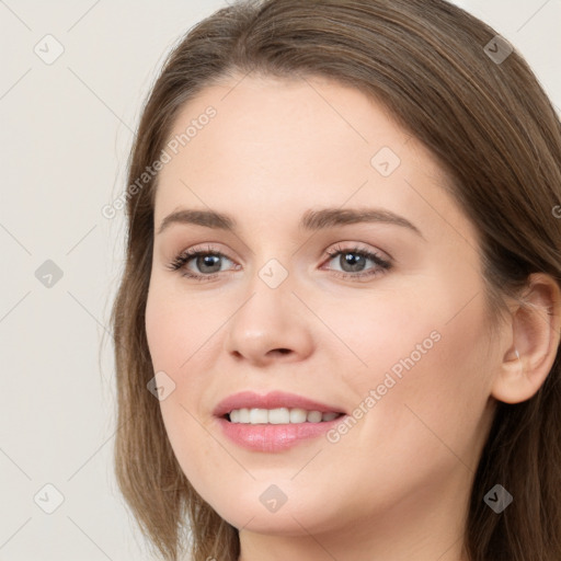 Joyful white young-adult female with long  brown hair and grey eyes