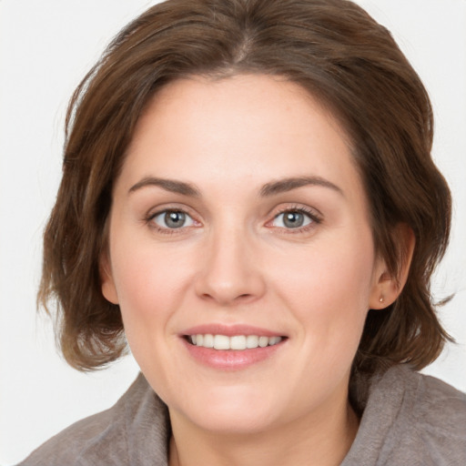 Joyful white young-adult female with medium  brown hair and grey eyes