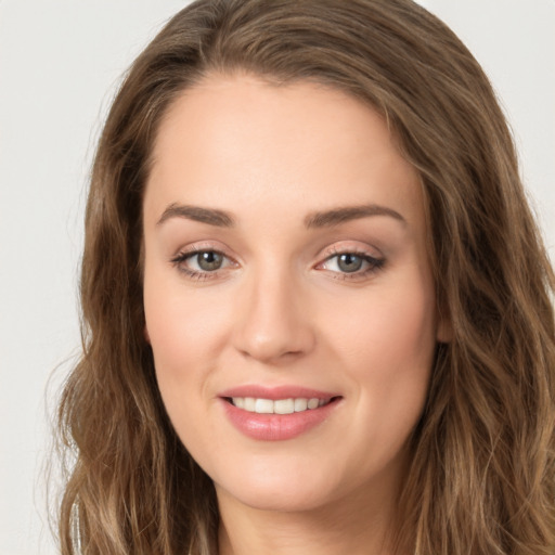 Joyful white young-adult female with long  brown hair and green eyes