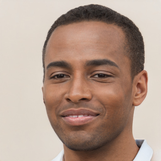 Joyful black young-adult male with short  brown hair and brown eyes