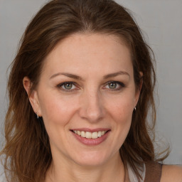 Joyful white adult female with long  brown hair and grey eyes