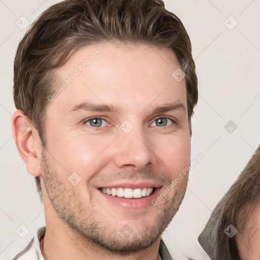 Joyful white young-adult male with short  brown hair and grey eyes