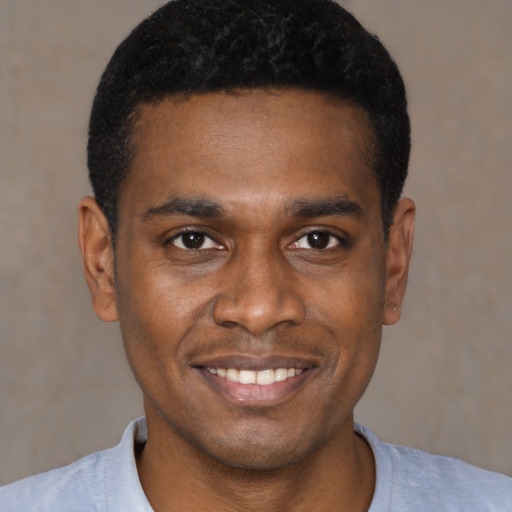 Joyful black young-adult male with short  black hair and brown eyes