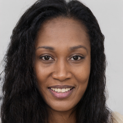 Joyful black young-adult female with long  brown hair and brown eyes