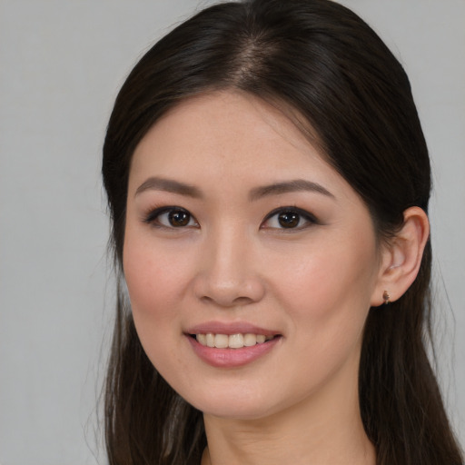 Joyful white young-adult female with long  brown hair and brown eyes