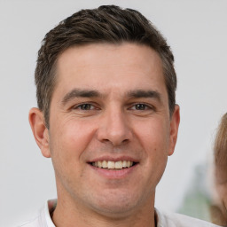 Joyful white young-adult male with short  brown hair and brown eyes