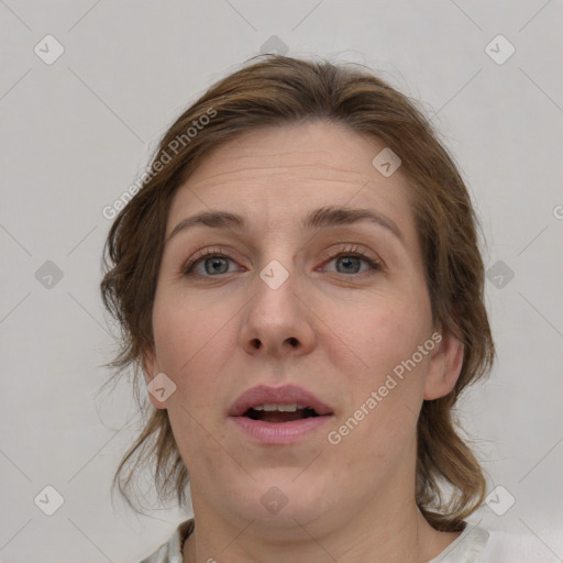 Joyful white adult female with medium  brown hair and blue eyes