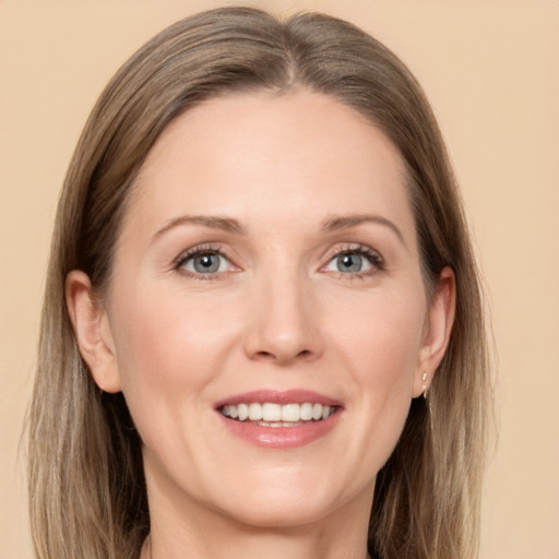 Joyful white adult female with long  brown hair and grey eyes