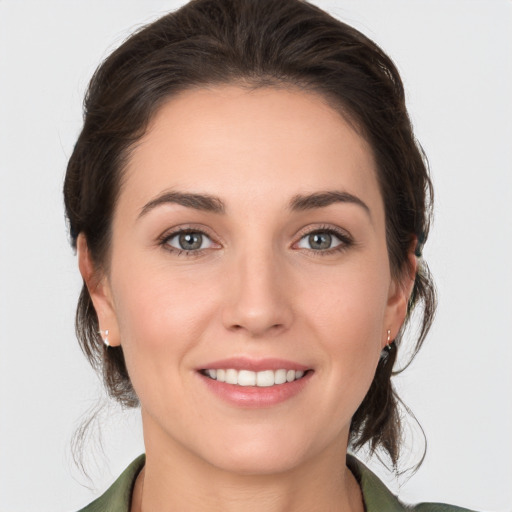 Joyful white young-adult female with medium  brown hair and grey eyes