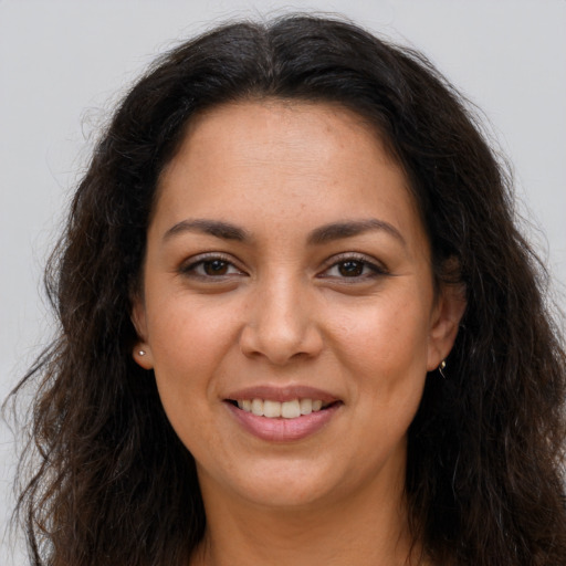 Joyful latino young-adult female with long  brown hair and brown eyes