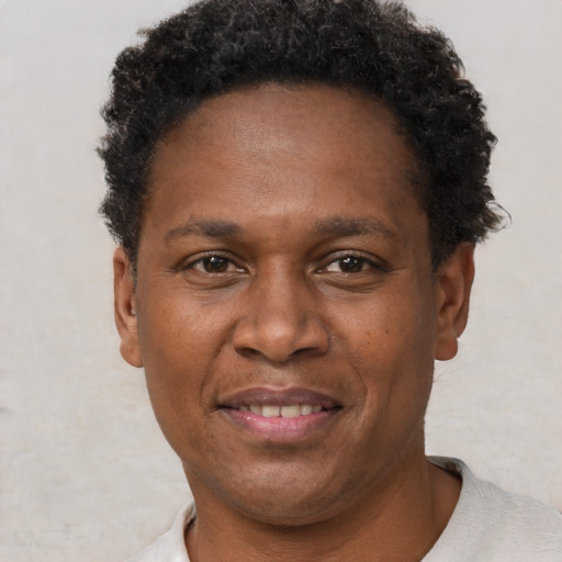 Joyful black adult male with short  brown hair and brown eyes