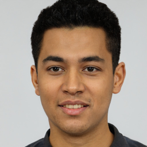 Joyful latino young-adult male with short  black hair and brown eyes