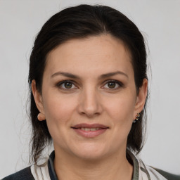 Joyful white young-adult female with medium  brown hair and grey eyes