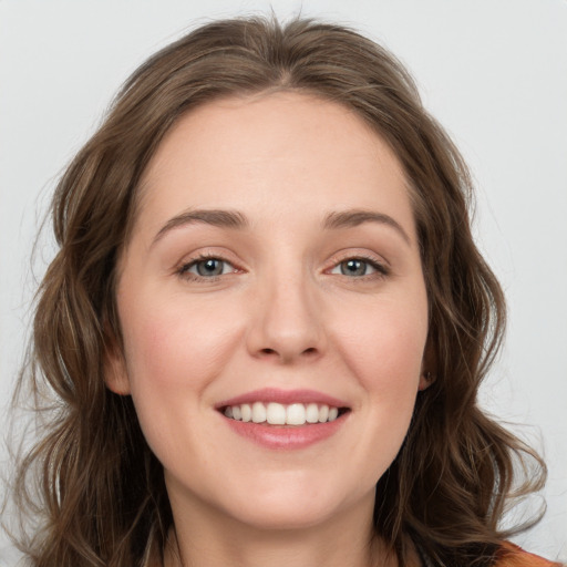 Joyful white young-adult female with long  brown hair and green eyes