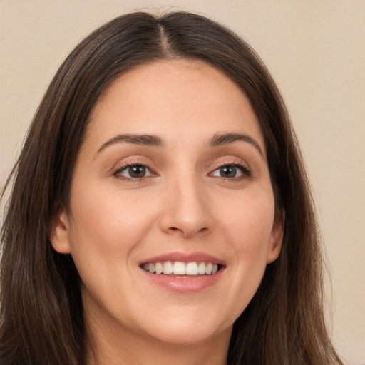 Joyful white young-adult female with long  brown hair and brown eyes