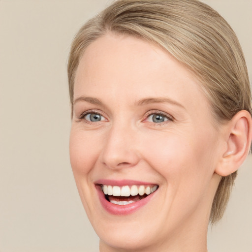 Joyful white adult female with medium  brown hair and blue eyes