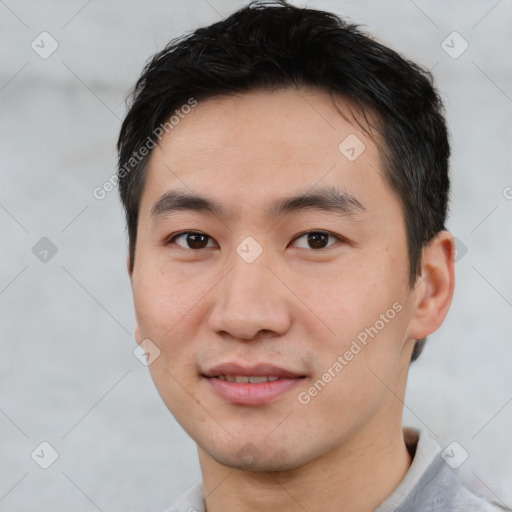 Joyful asian young-adult male with short  black hair and brown eyes