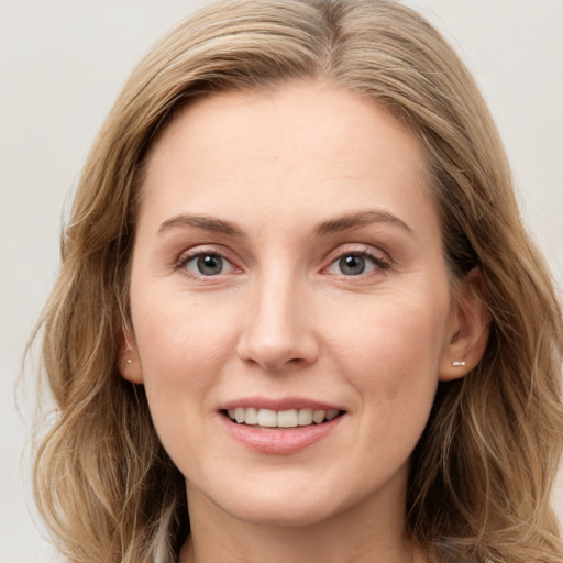 Joyful white young-adult female with long  brown hair and blue eyes