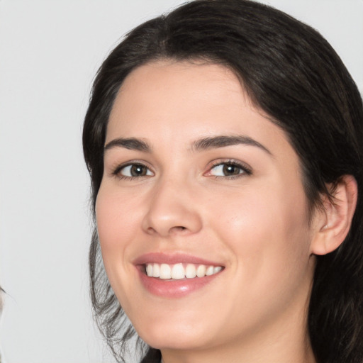 Joyful white young-adult female with medium  black hair and brown eyes