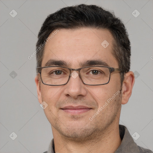 Joyful white adult male with short  black hair and brown eyes