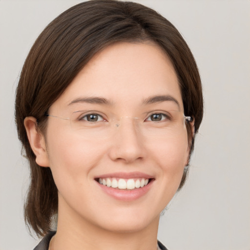 Joyful white young-adult female with medium  brown hair and grey eyes