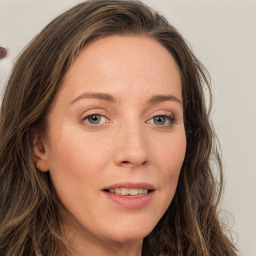 Joyful white young-adult female with long  brown hair and green eyes