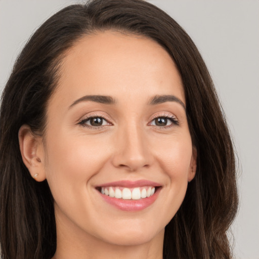 Joyful white young-adult female with long  brown hair and brown eyes