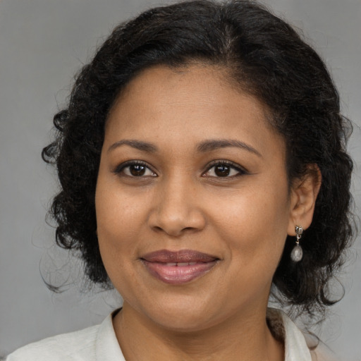 Joyful black adult female with medium  brown hair and brown eyes